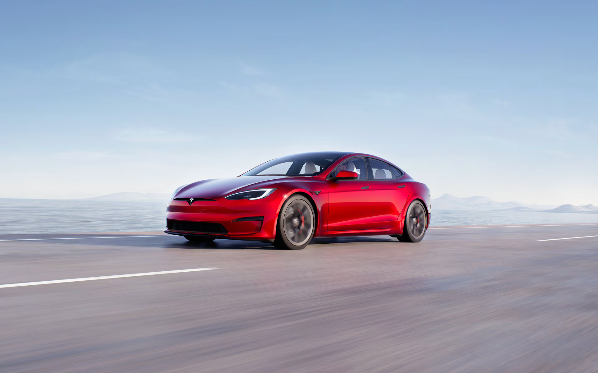 Solid black Model S accelerating on an elevated highway 